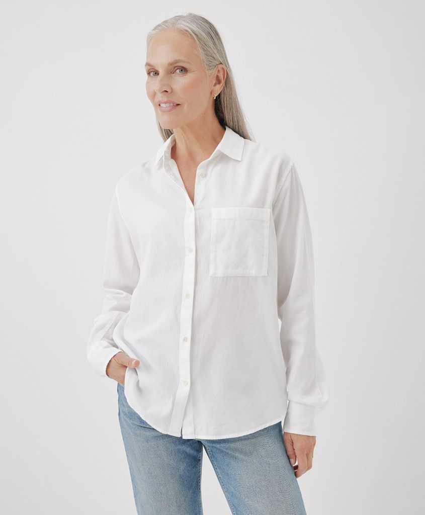 An older woman wearing an organic cotton button down shirt for a sustainable capsule wardrobe