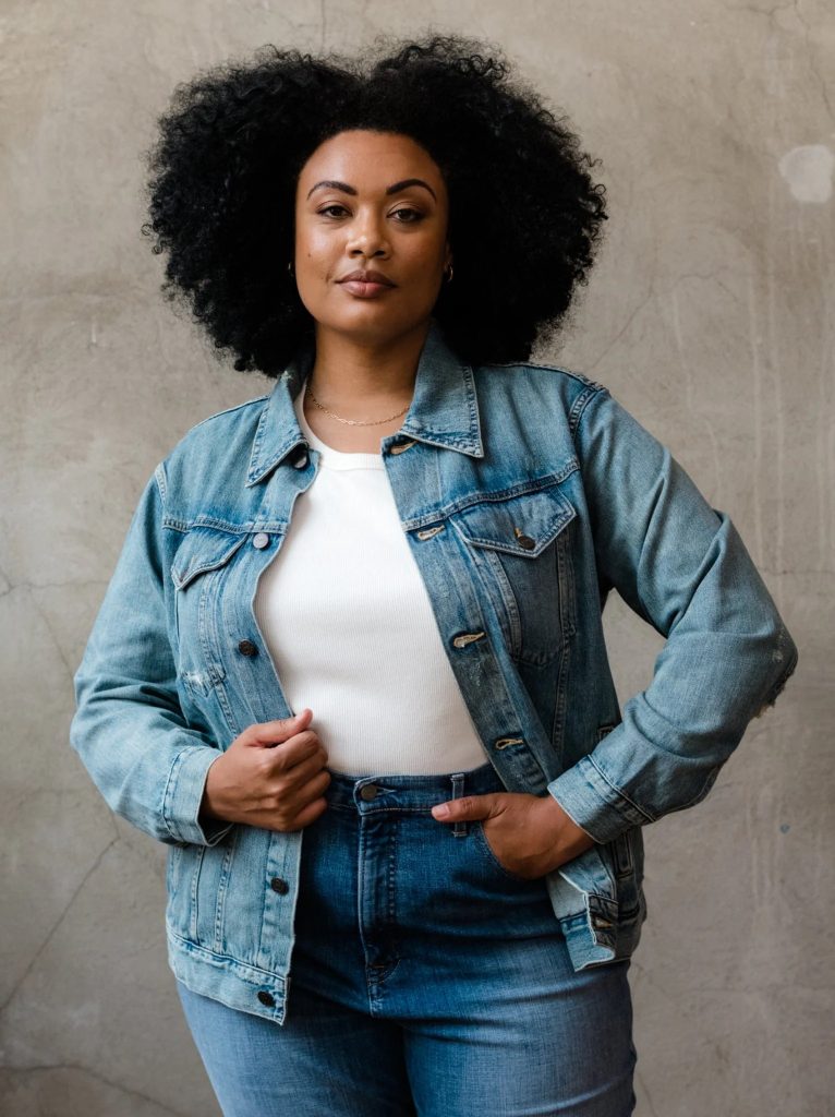 A woman wearing an organic cotton denim jacket from ABLE for a sustainable capsule wardrobe piece