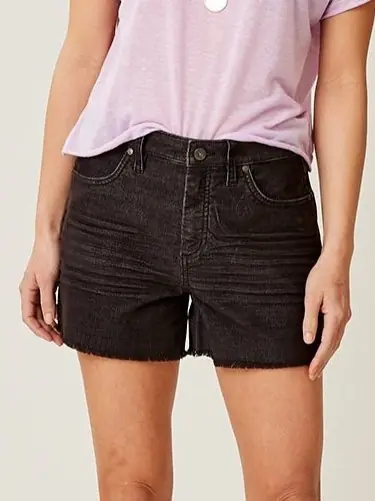 A woman wearing a black pair of organic cotton denim shorts from Carve for a sustainable capsule wardrobe piece