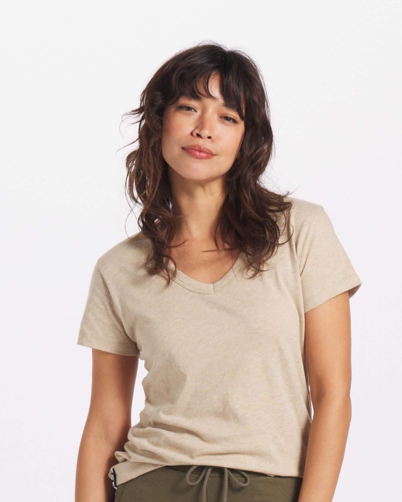 A woman wearing a tan organic basic t-shirt for a capsule wardrobe from PAKA