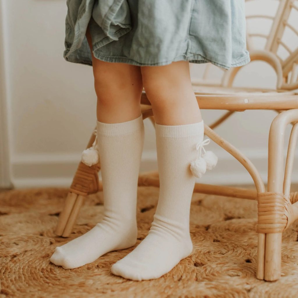 A little girl wearing organic cotton knee socks from affordable sustainable clothing brand Q for Quinn