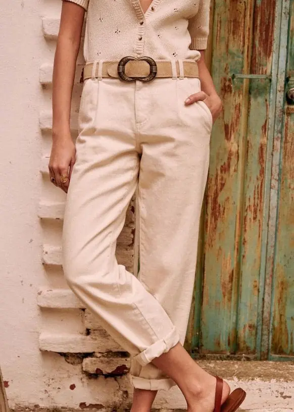 A woman wearing a pair of light denim trousers made of organic cotton from Sezane for a sustainable capsule wardrobe piece