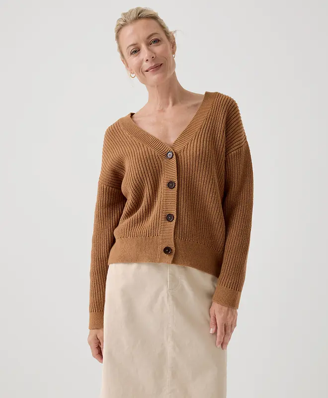 A woman wearing a camel colored organic cotton cardigan from Pact for a sustainable capsule wardrobe 