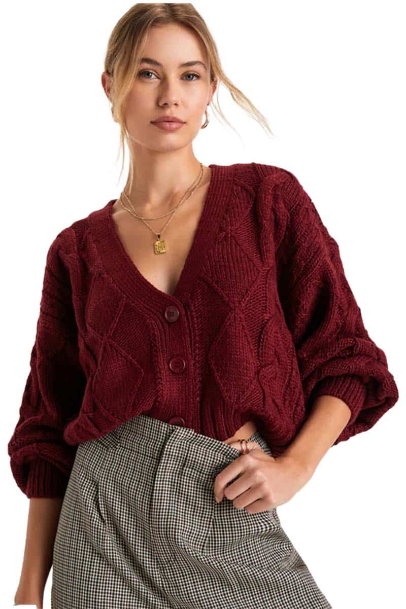 Model wears oversized cardigan with checked pants as an example of cozy girl style.