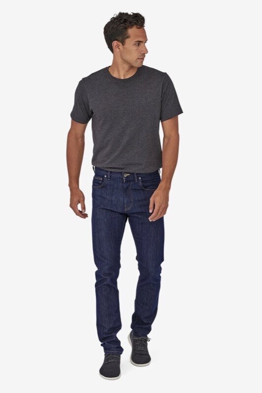 a man wearing a pair of dark denim sustainable jeans from patagonia