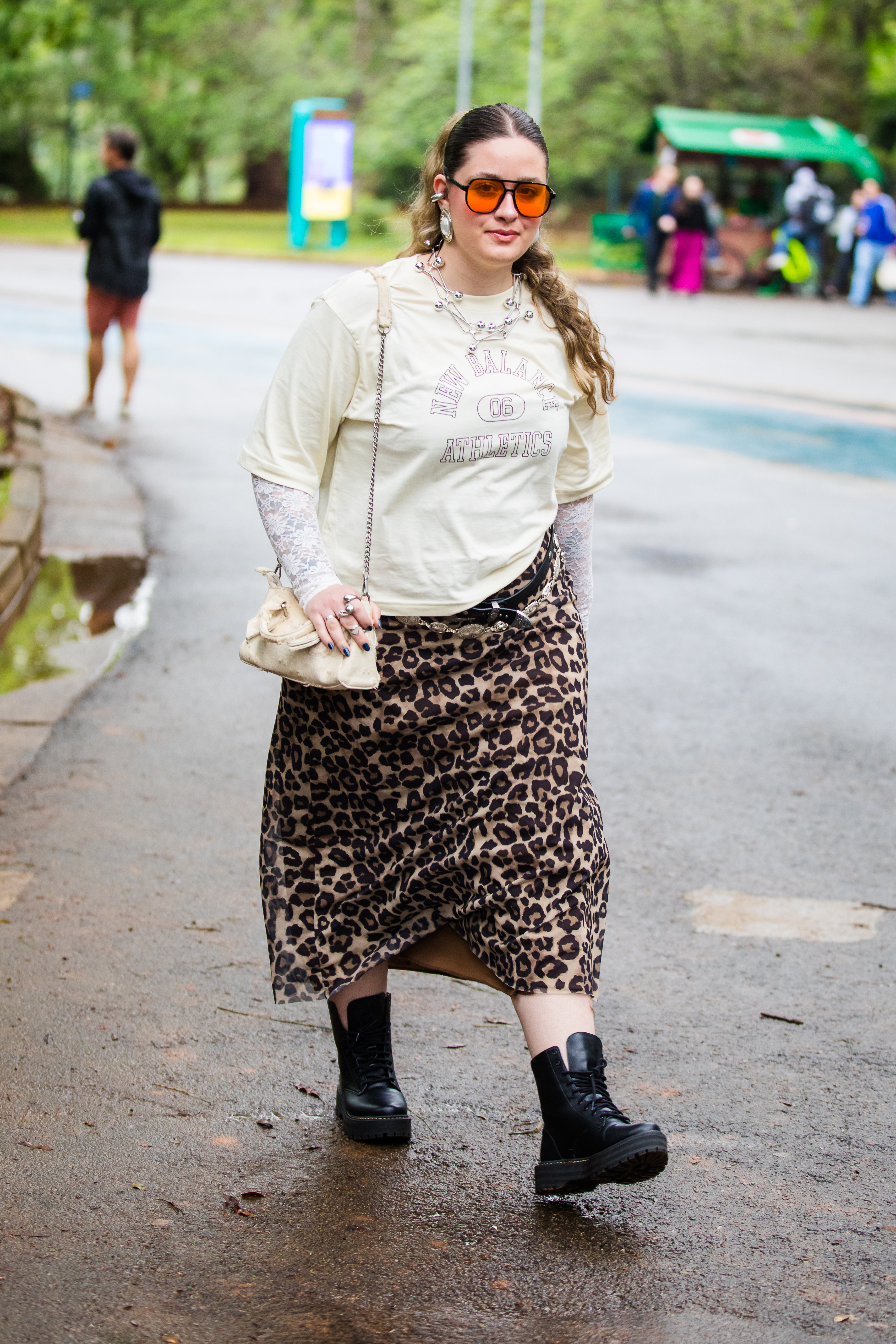 Street style photo of woman wearing slip skirt and boots.