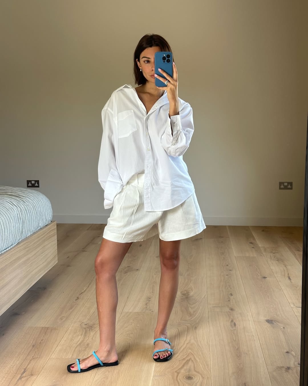 woman wearing oversized white button-down shirt and white loose shorts summer 2025
