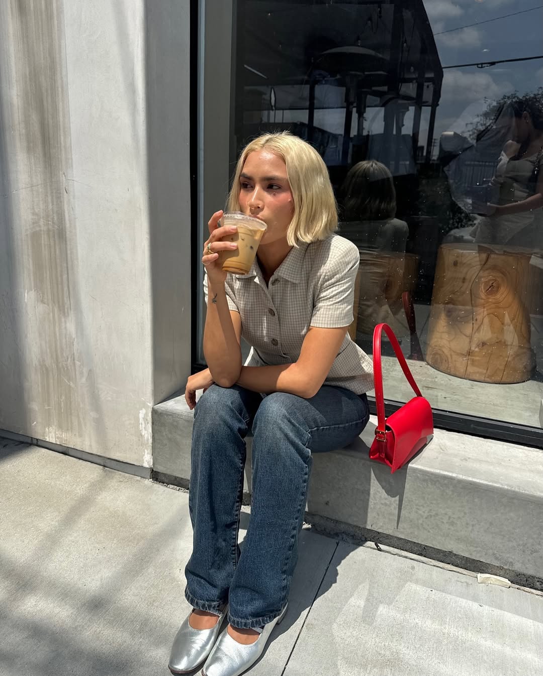 Woman wearing short sleeve polo with jeans and silver ballet flats.