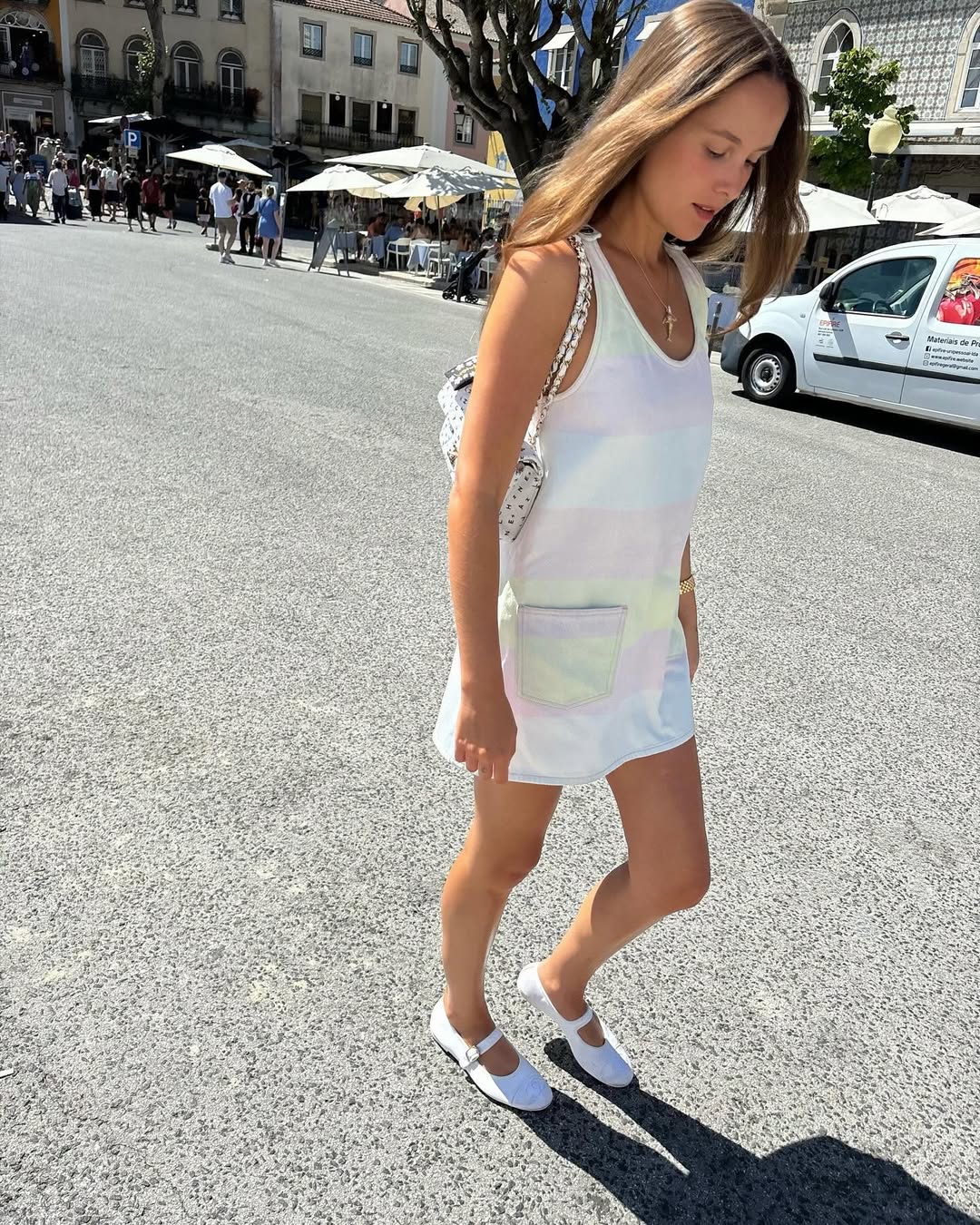 Woman wearing white minidress with ballet flats.