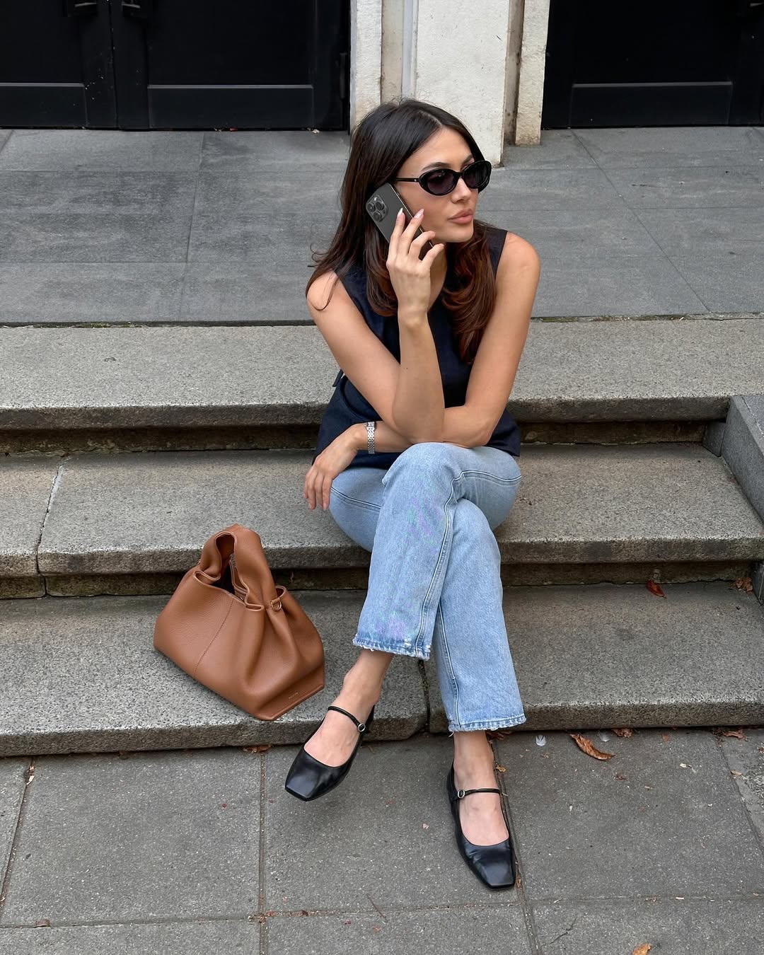 Woman wearing black top and jeans with ballet flats in a summer 2025 outfit.