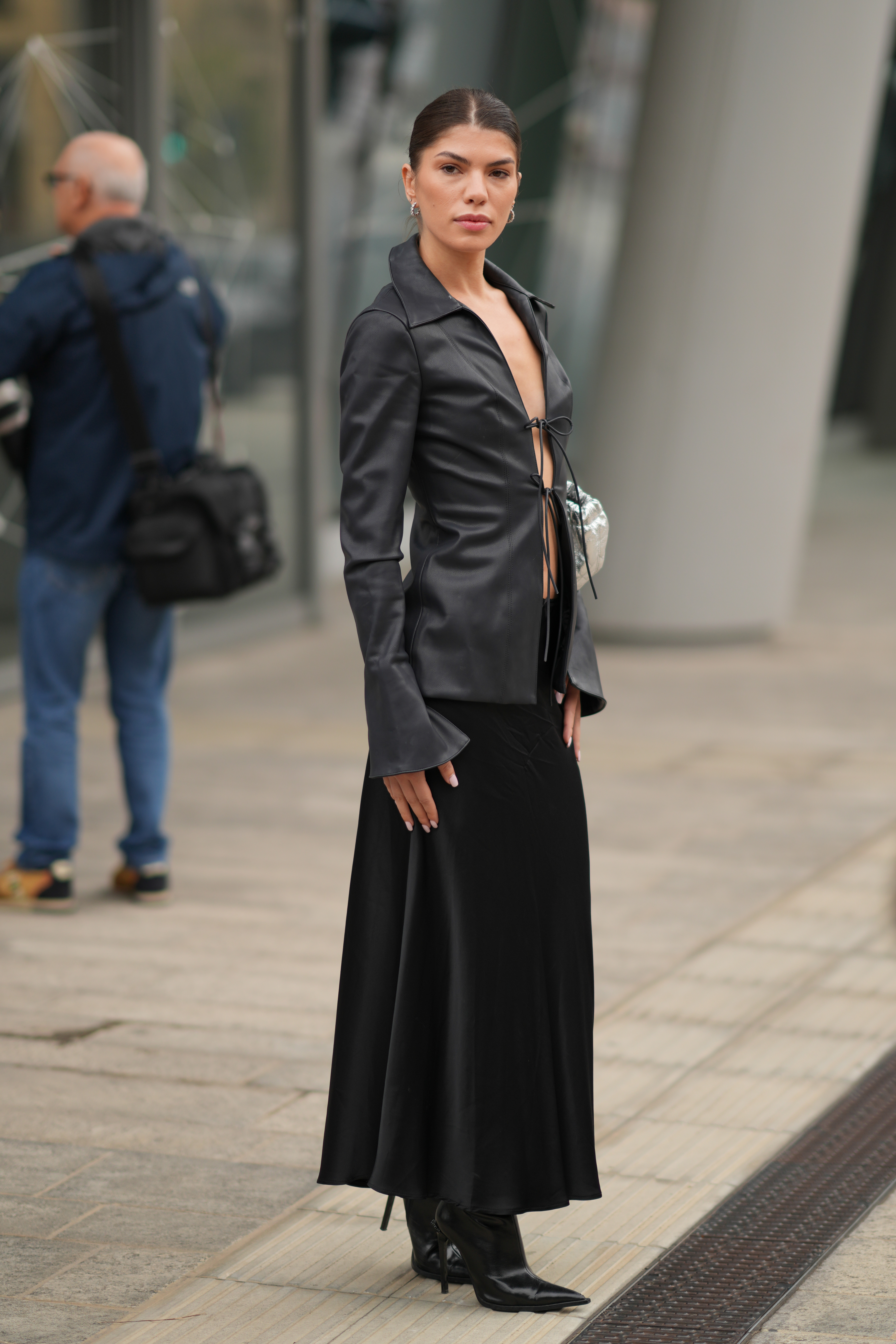 Street style photo of woman wearing slip skirt and boots.
