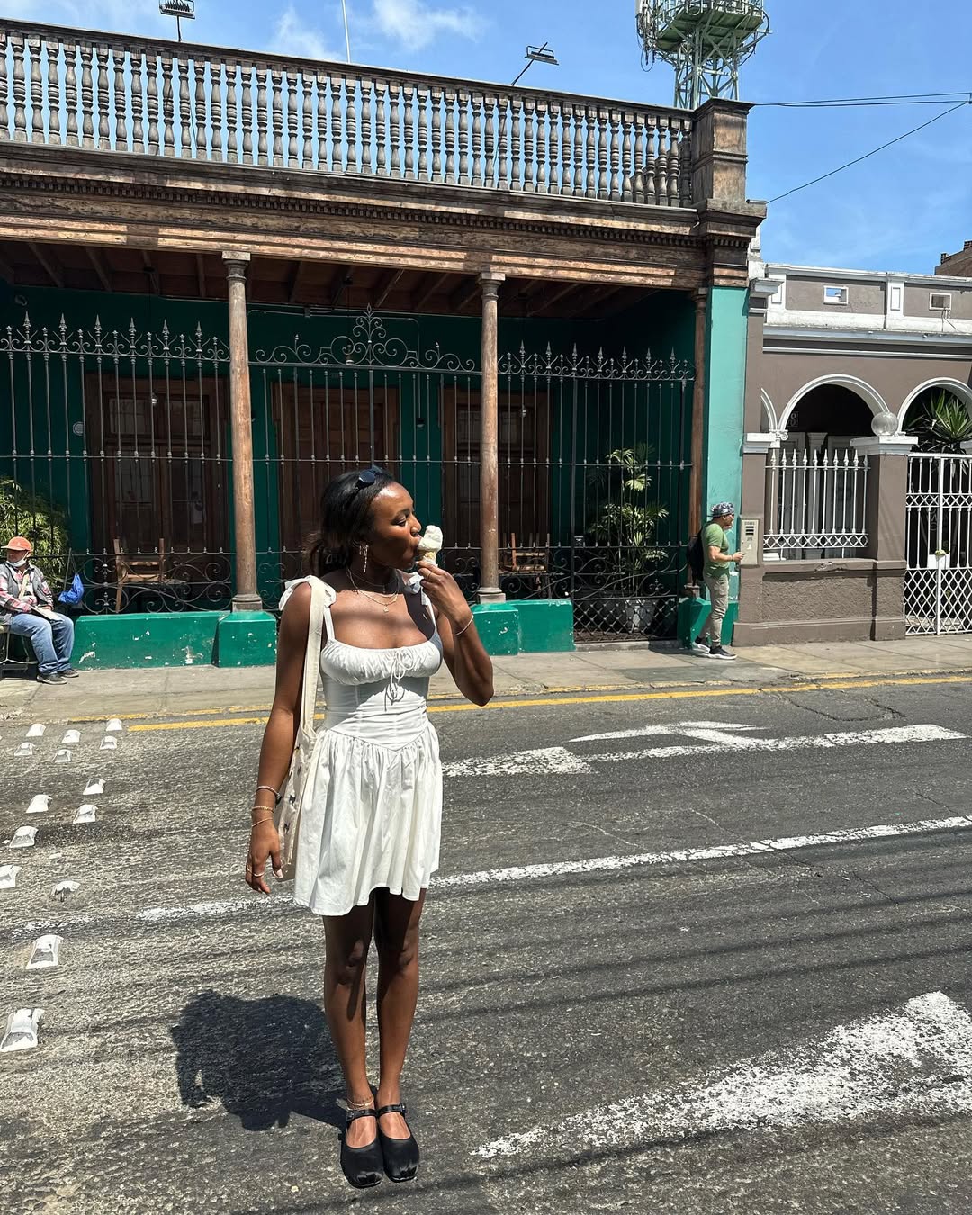 Woman wearing white minidress with ballet flats in a summer 2025 outfit.