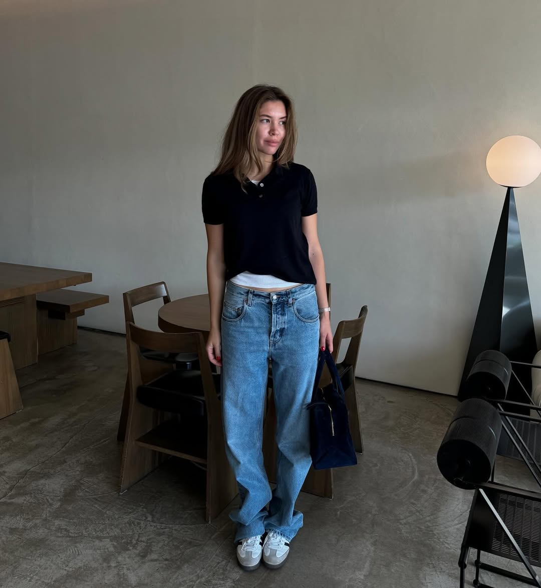 woman wearing loose jeans with black polo shirt and sneakers