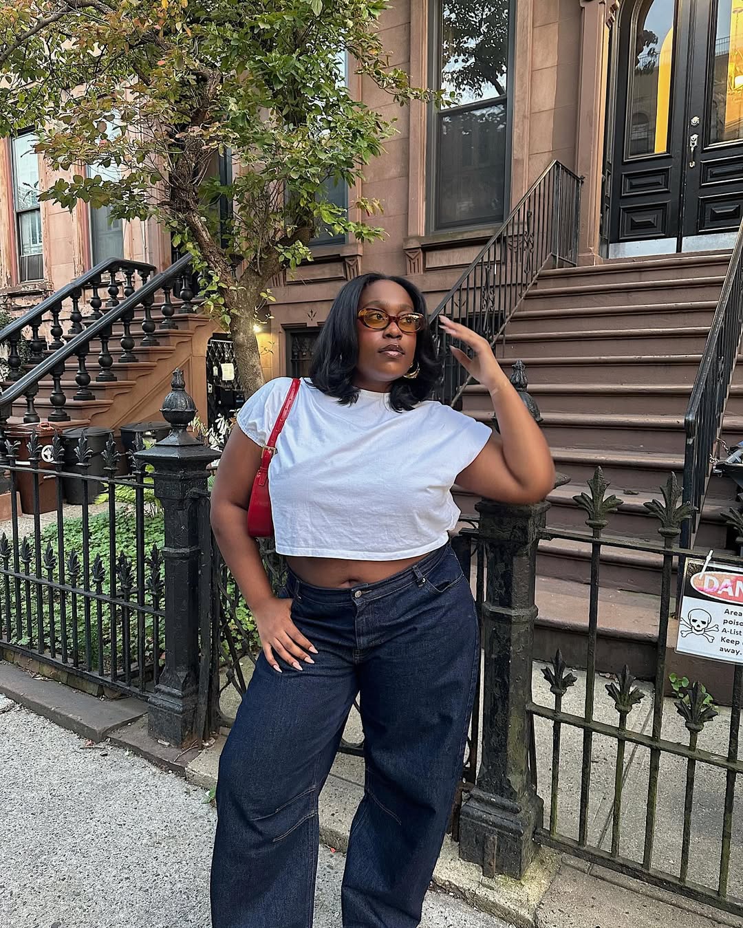 Woman wearing loose jeans with fitted white T-shirt in a summer 2025 outfit.