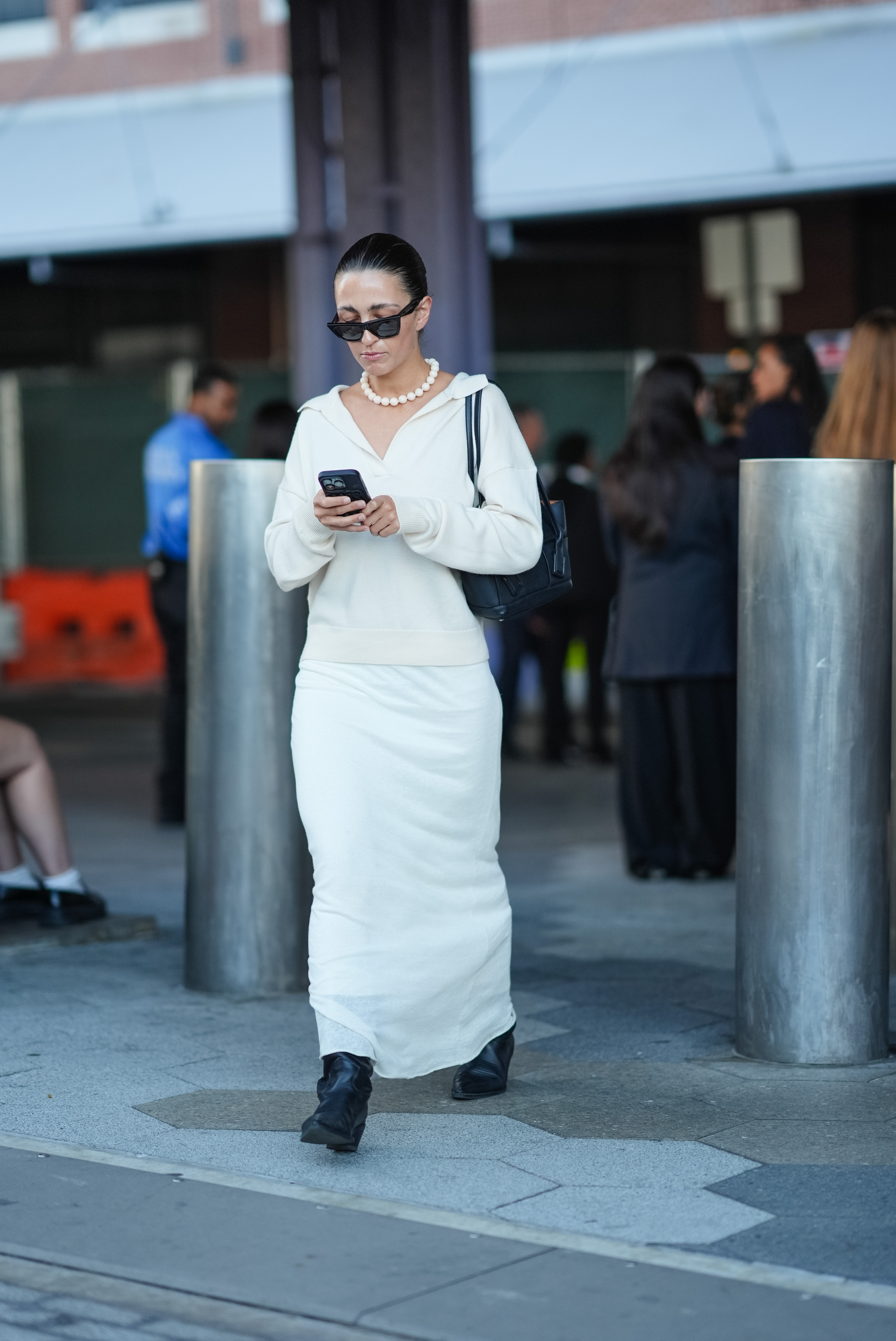 Street style photo of woman wearing slip skirt and boots.