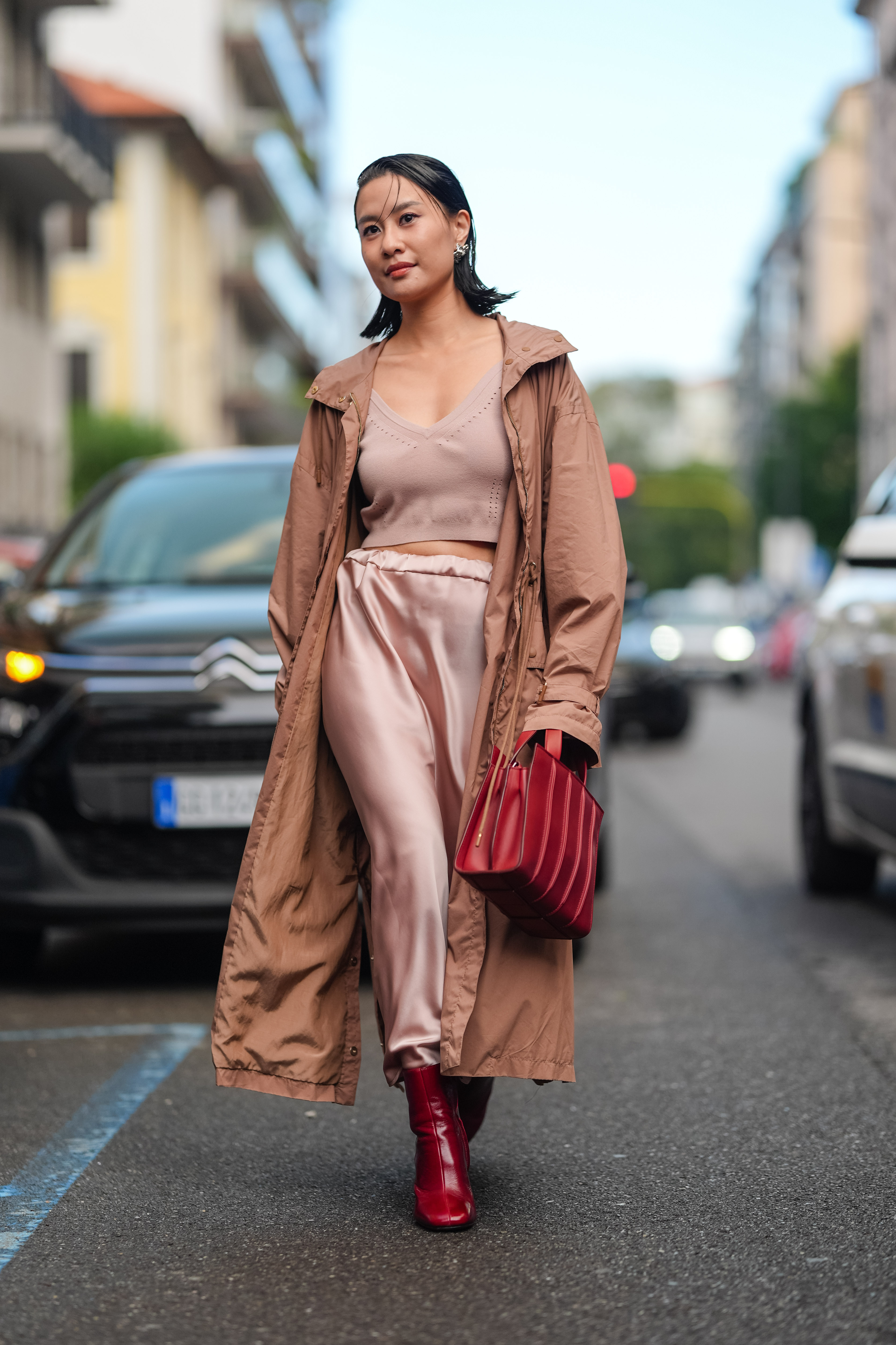 Street style photo of woman wearing slip skirt and boots.