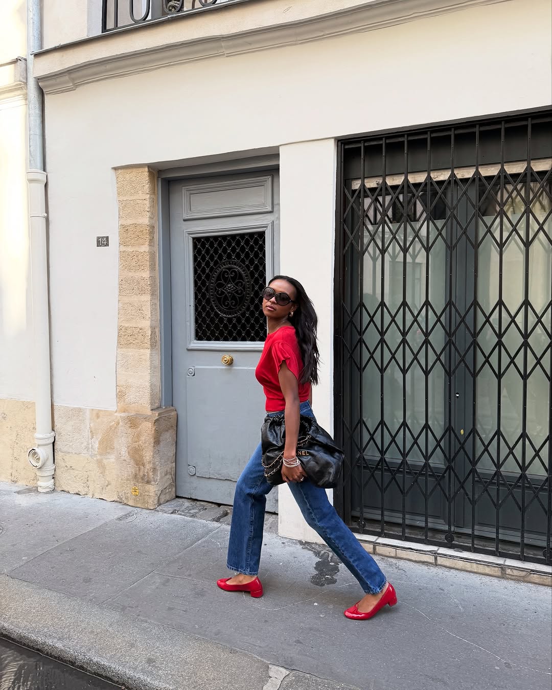 woman wearing dark denim and red t-shirt and red shoes
