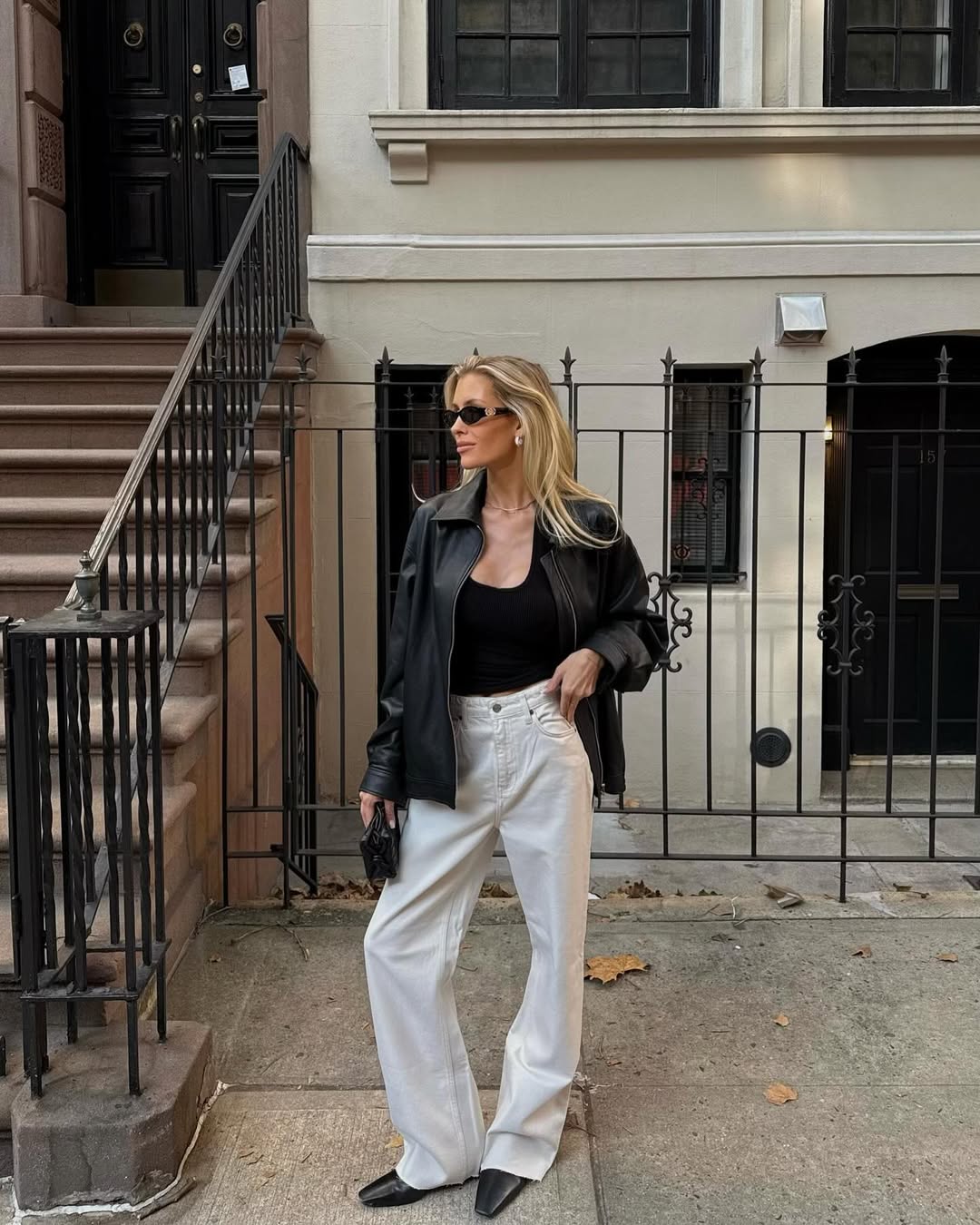 Woman wearing loose jeans with fitted black tank in a summer 2025 outfit.