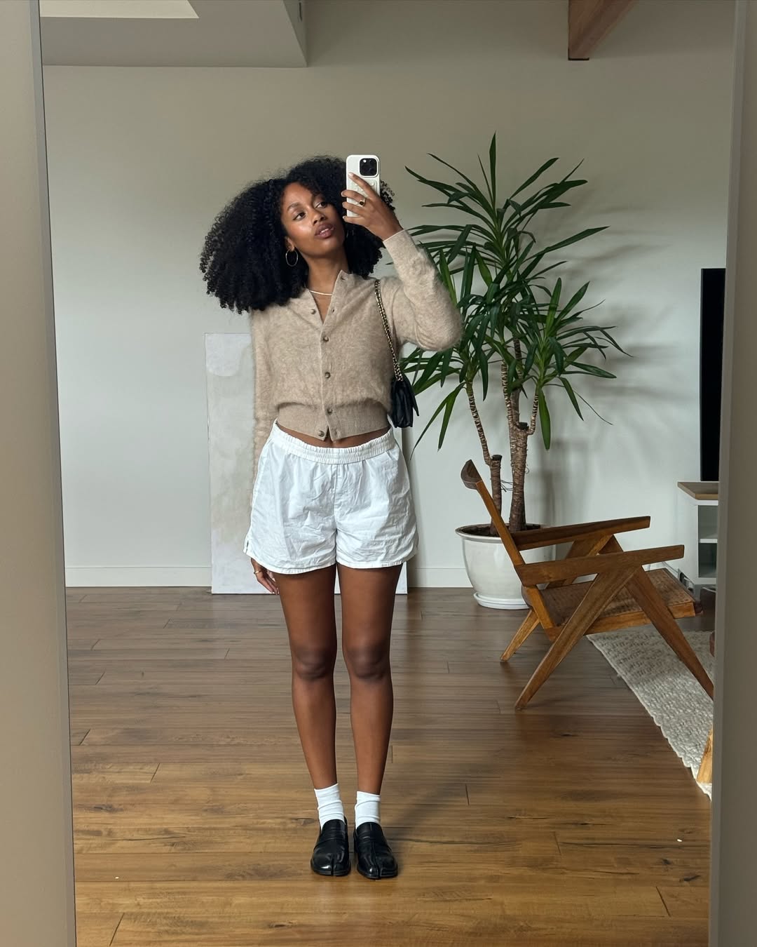 woman wearing fitted cardigan and white boxer shorts with black loafers