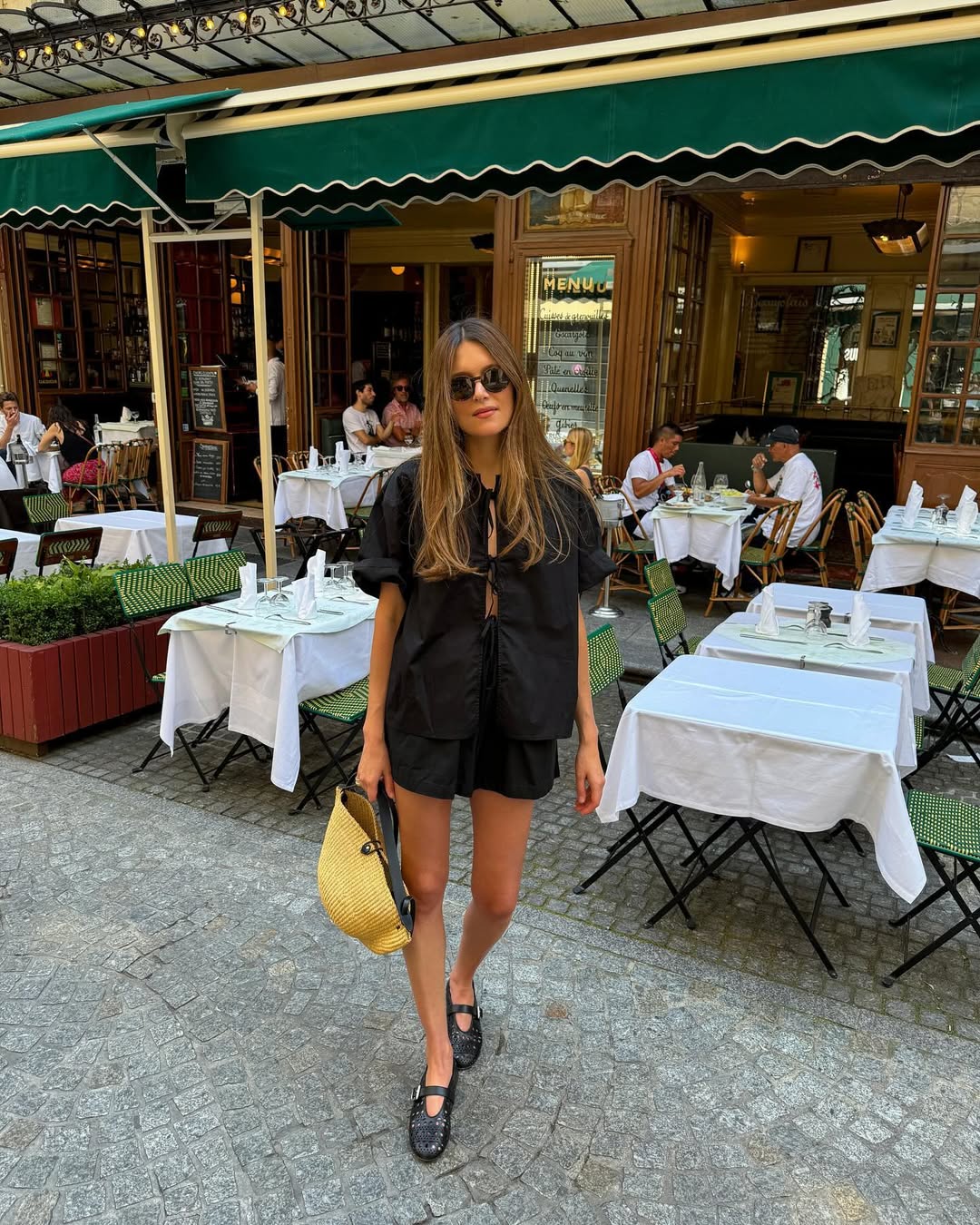 Woman wearing matching black set with ballet flats in a summer 2025 outfit.