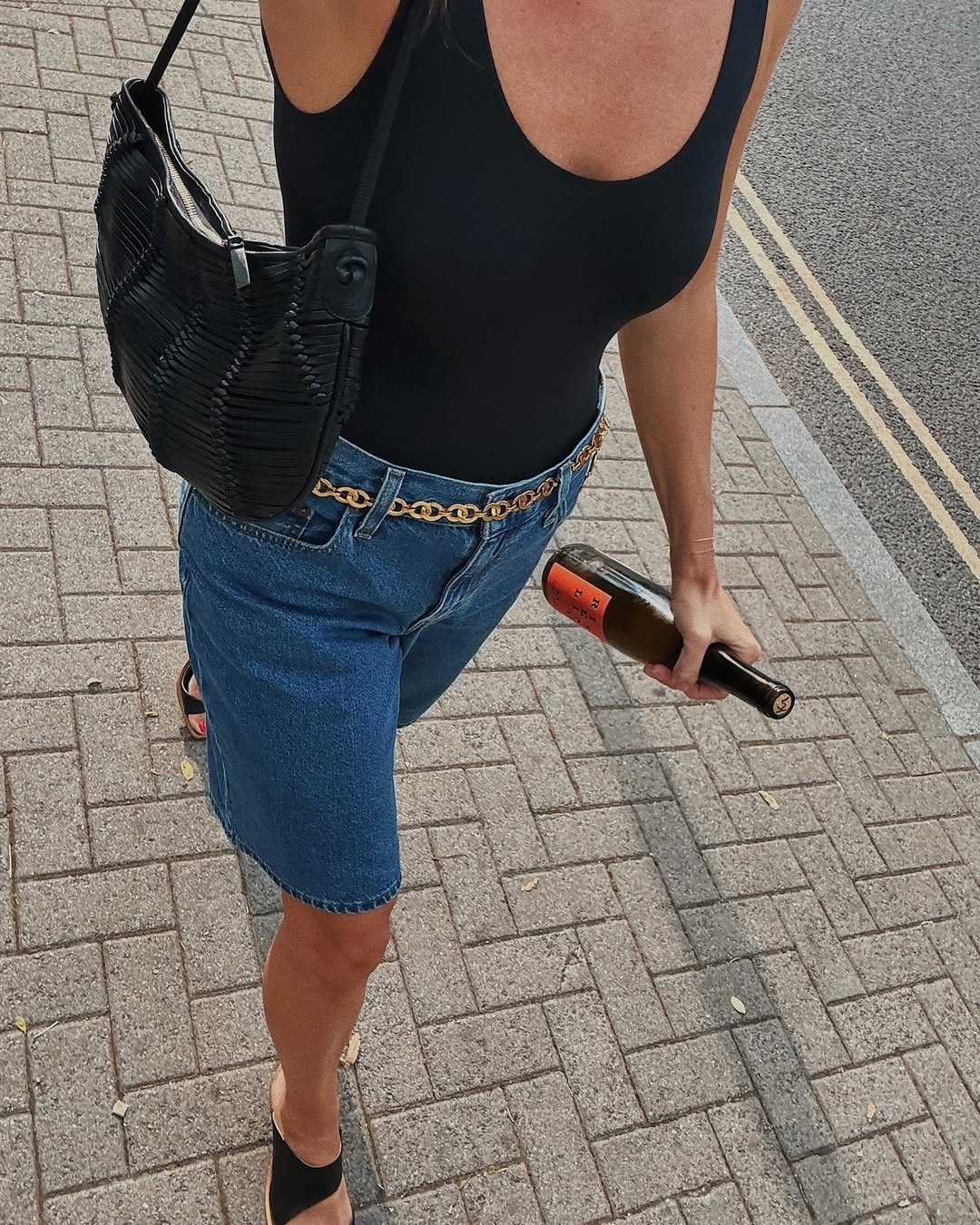 woman wearing black tank and long denim shorts