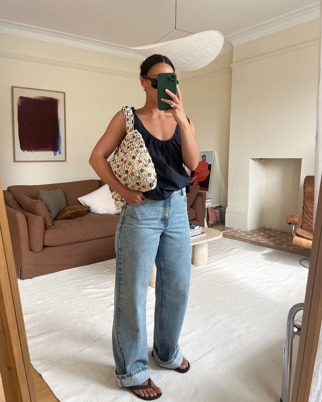 woman wearing cuffed jeans with black tank top