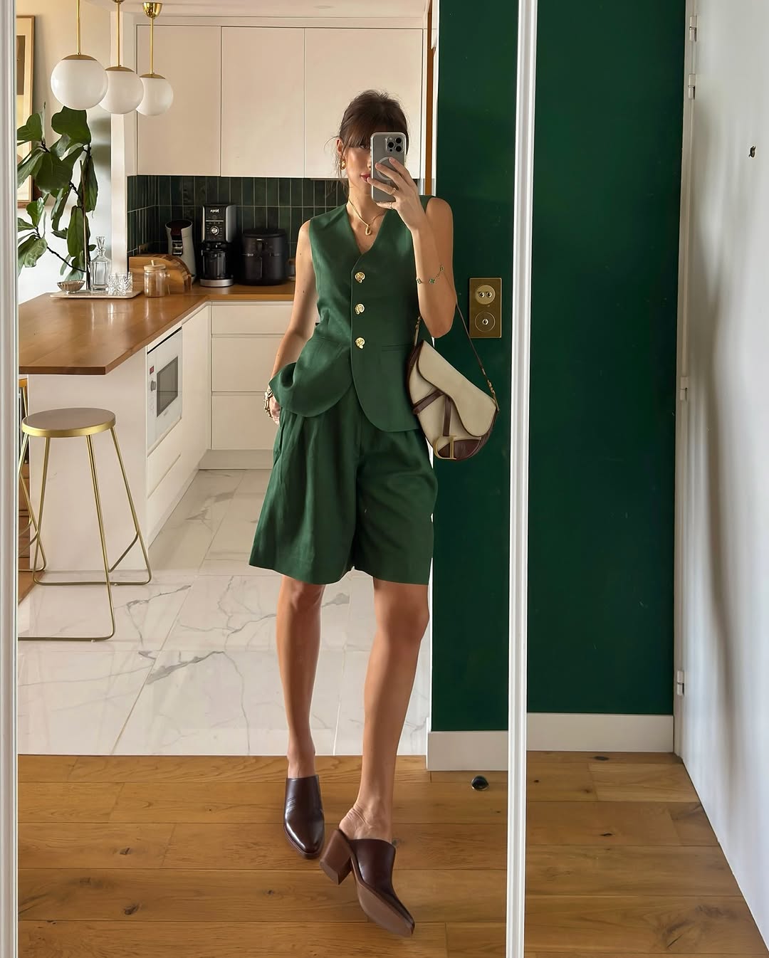 woman wearing green vest and long shorts with brown mules