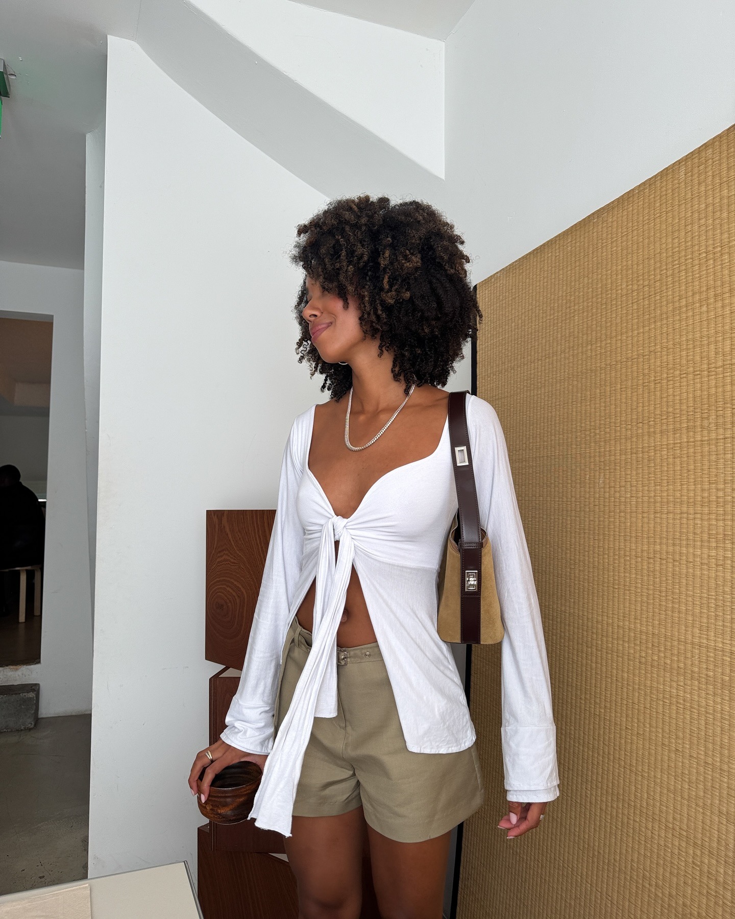 Influencer wearing a summer outfit with white top and tan A-line shorts