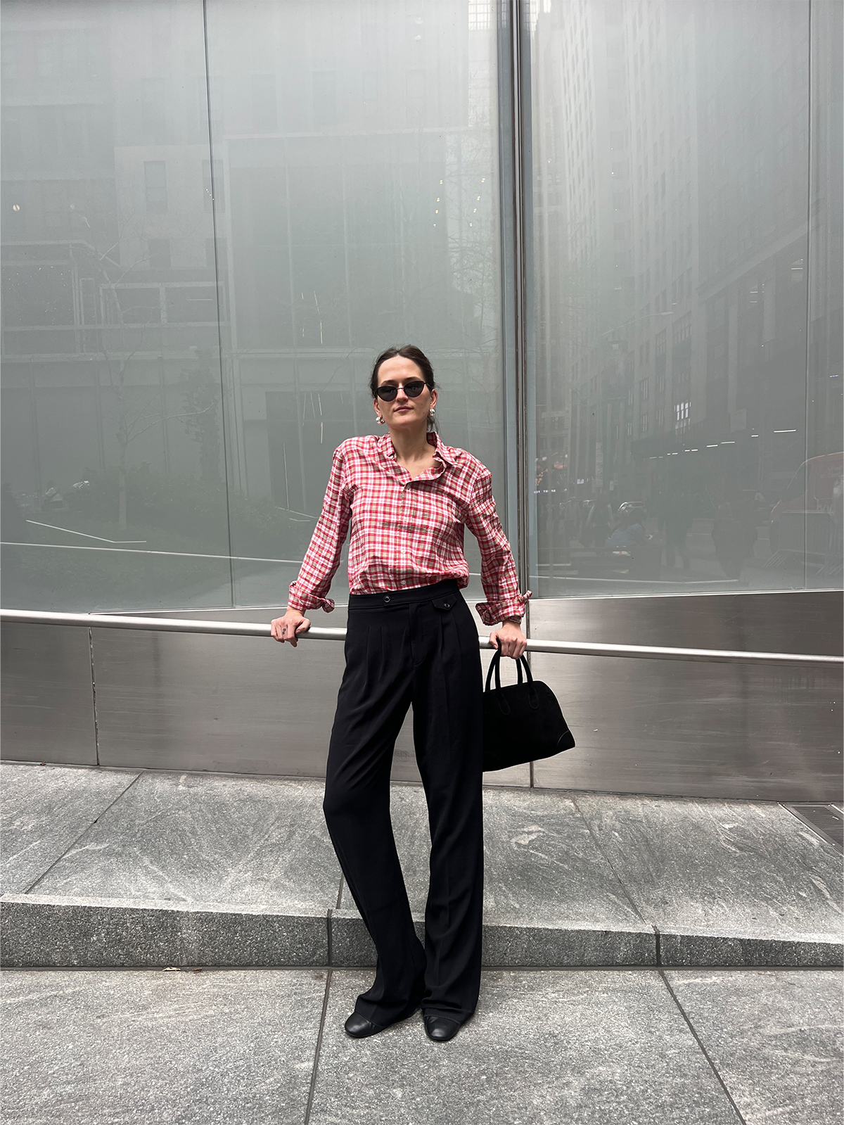 Eliza Huber wearing a red plaid shirt with black trousers.