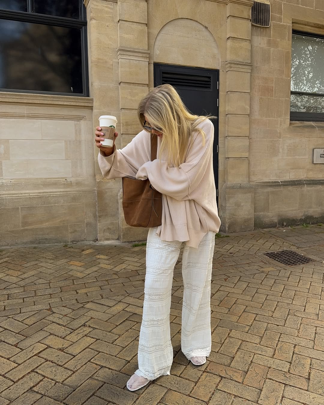 woman wearing ballet flats with white pants summer 2025