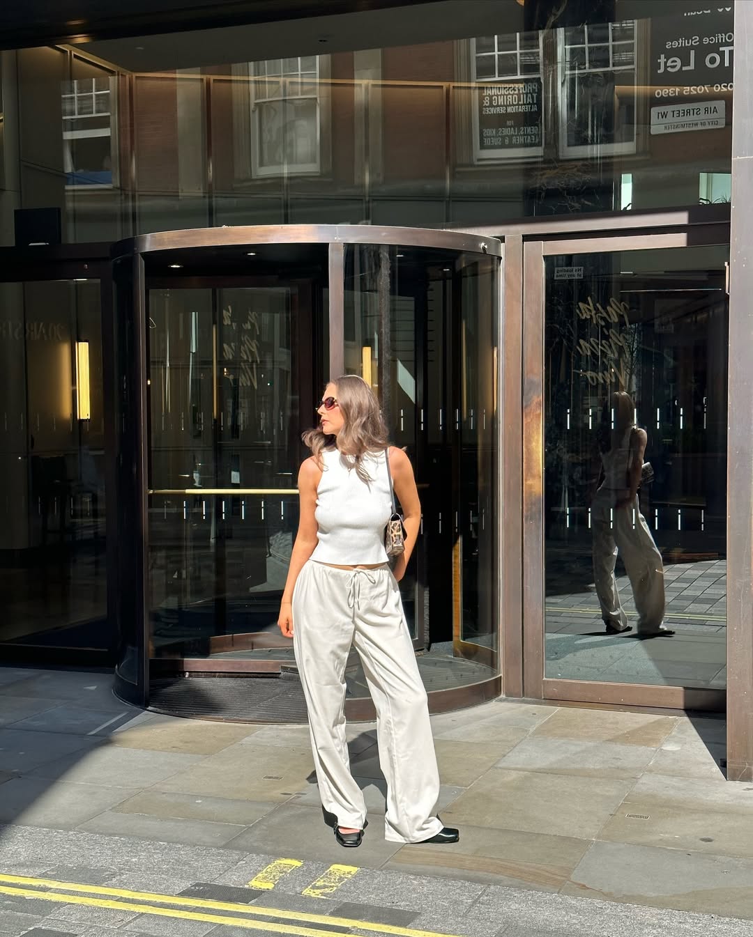 woman wearing ballet flats with white pants summer 2025