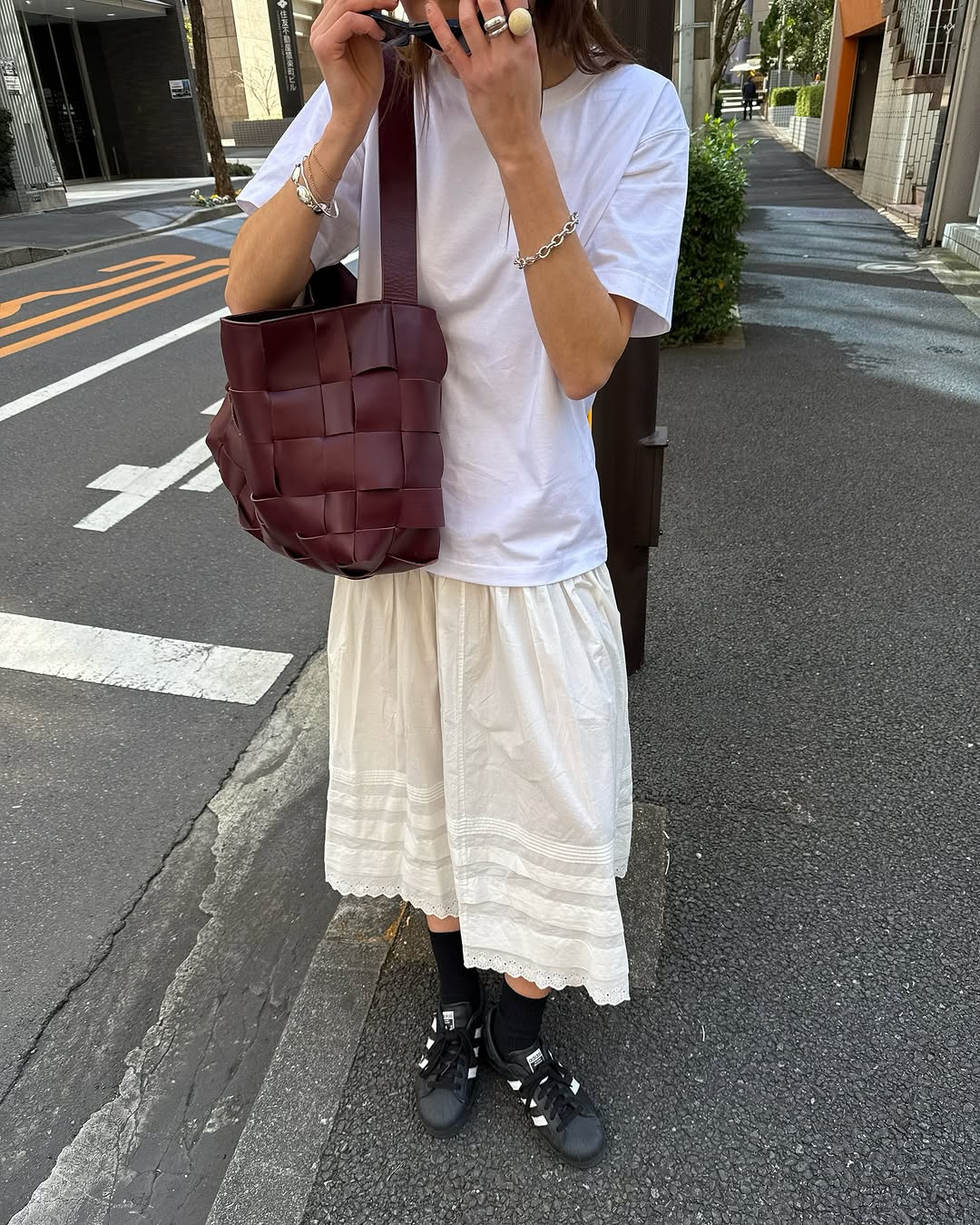 woman wearing white maxi skirt with adidas sambas