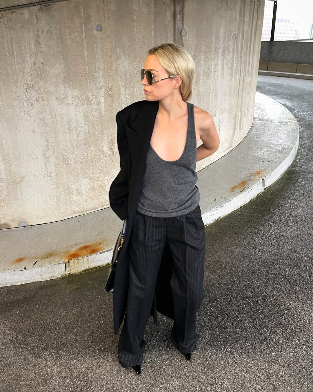 woman wearing dark grey tank top and black trousers