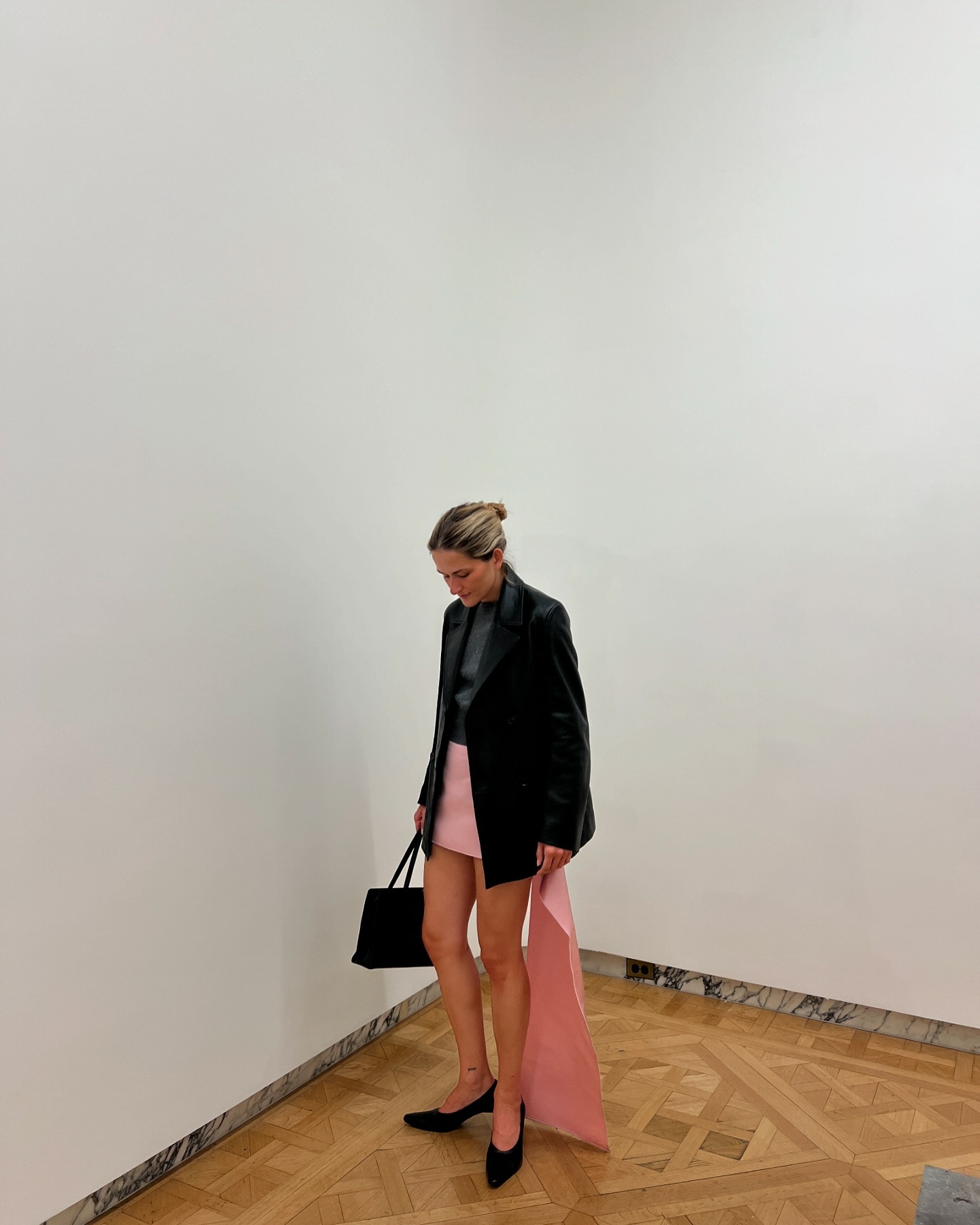 Eliza Huber wearing a leather blazer and pink Prada skirt.