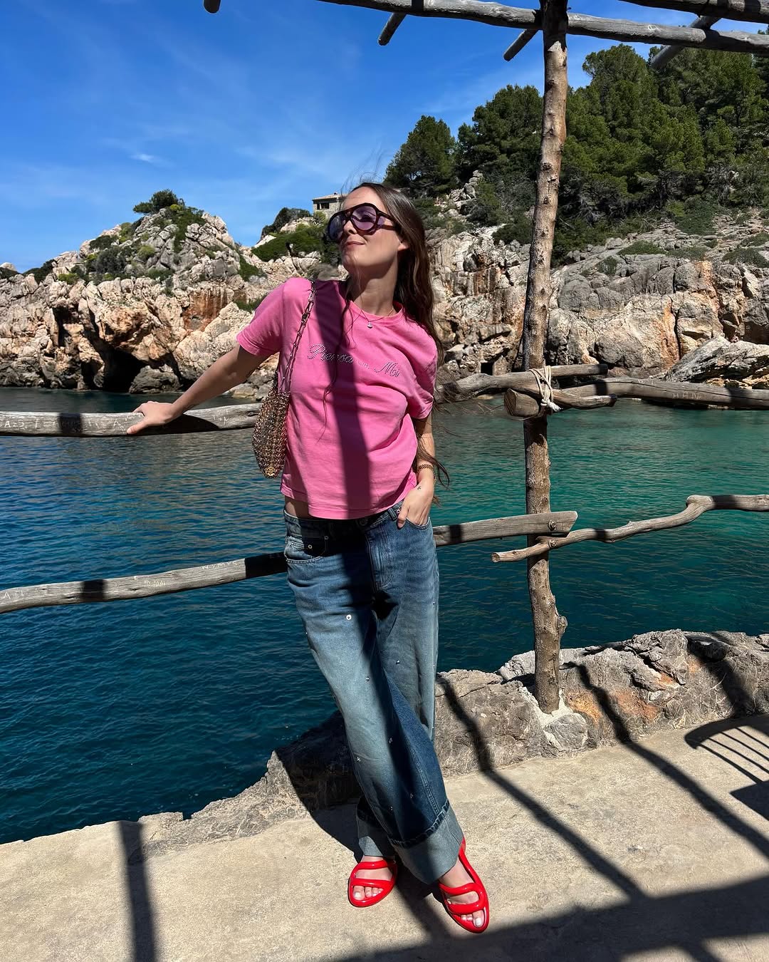 woman wearing pink t-shirt, jeans, and red sandals