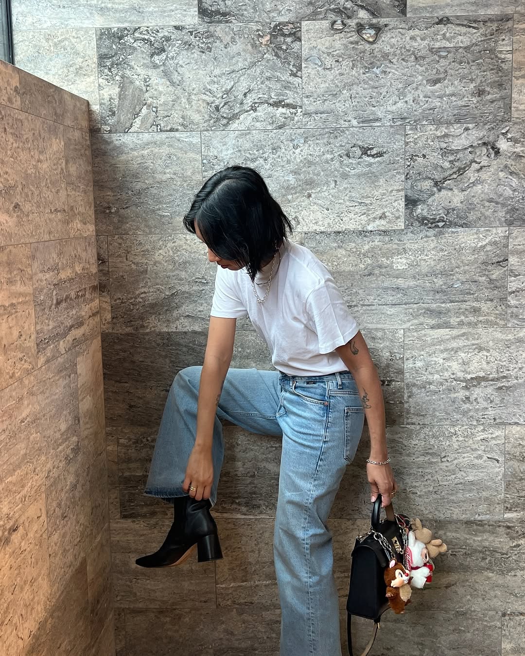 Woman wearing vintage jeans with white t shirt and cool bag.