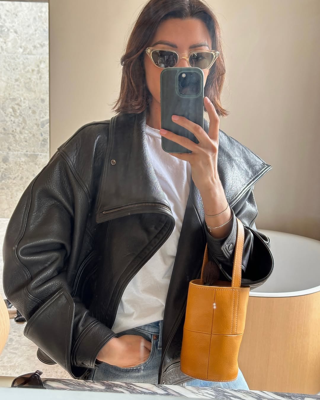 Woman wearing vintage jeans with white t shirt and cool bag.