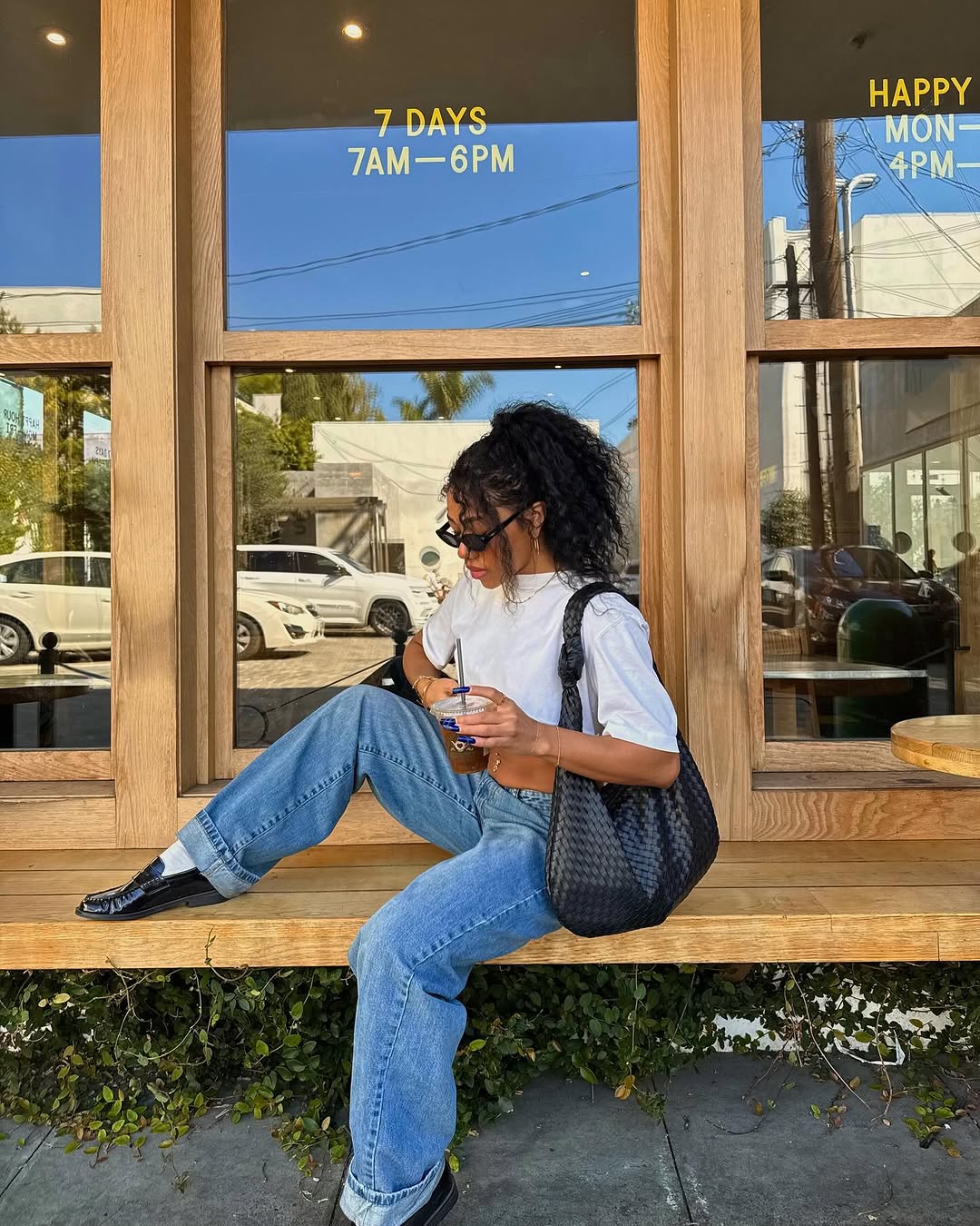Woman wearing vintage jeans with white t shirt and cool bag.
