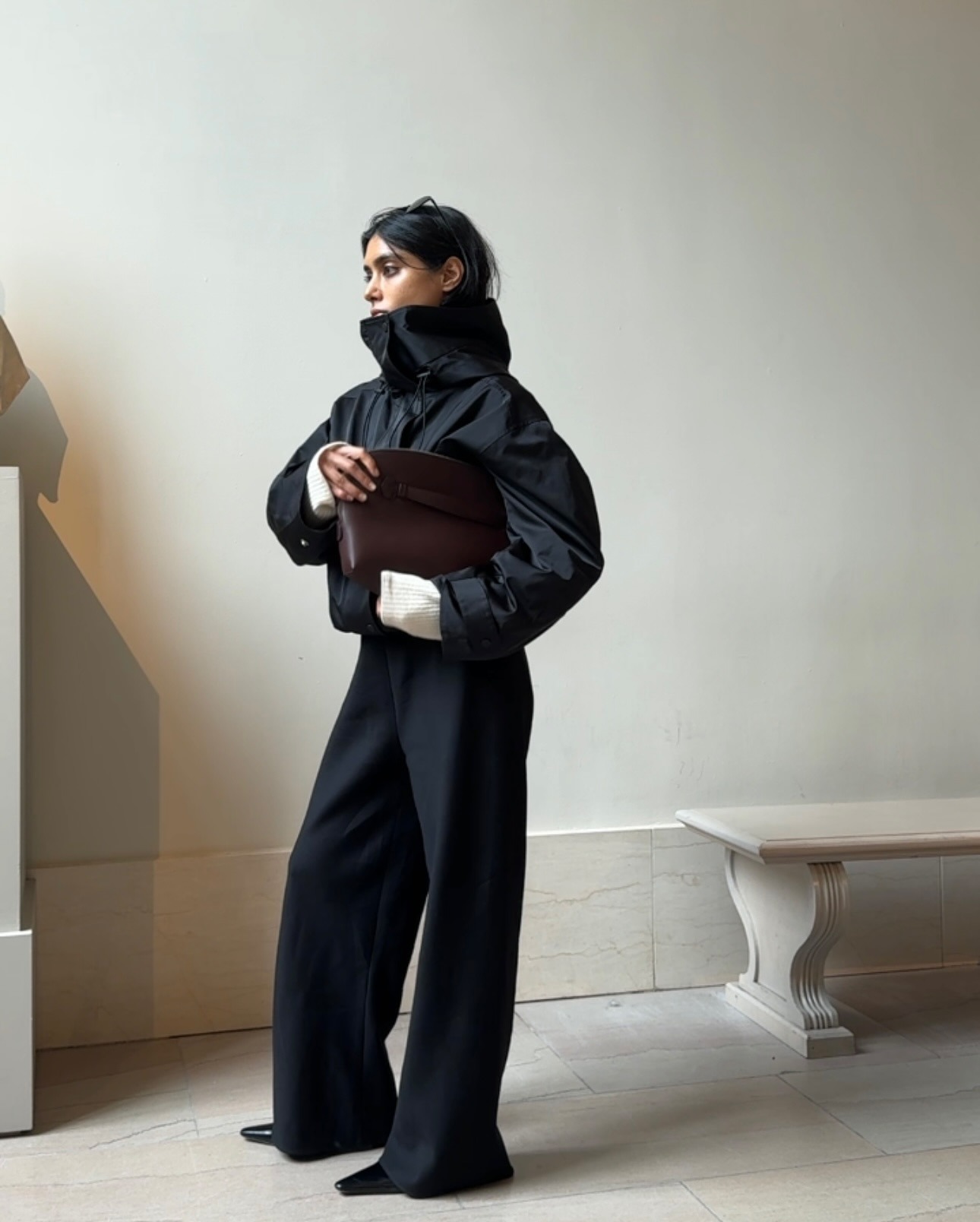 @shayinjune wearing a sporty jacket with black trousers and a clutch.