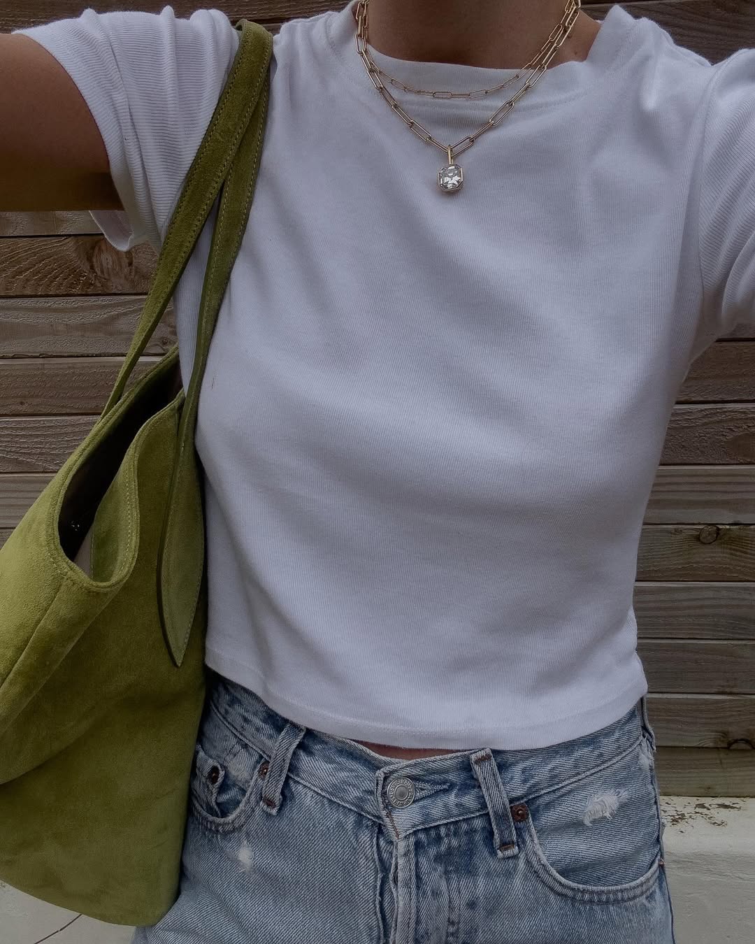 Woman wearing vintage jeans with white t shirt and cool bag.