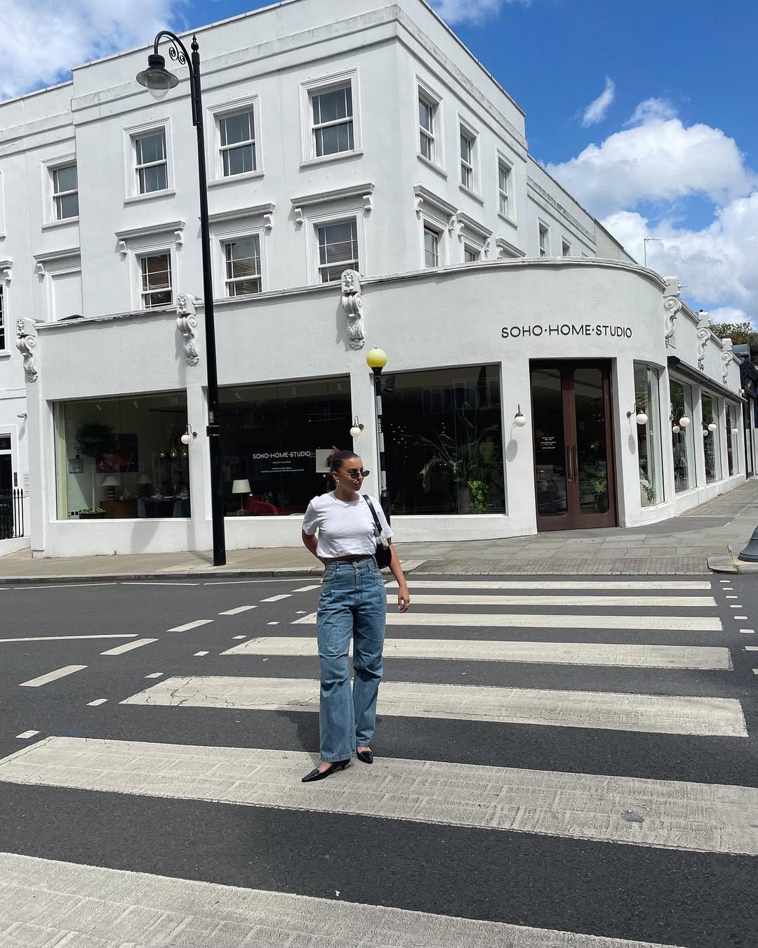 Woman wearing vintage jeans with white t shirt and cool bag.