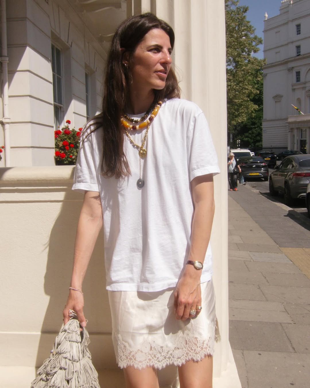 A woman wearing white t-shirt and mini skirt summer 2025.