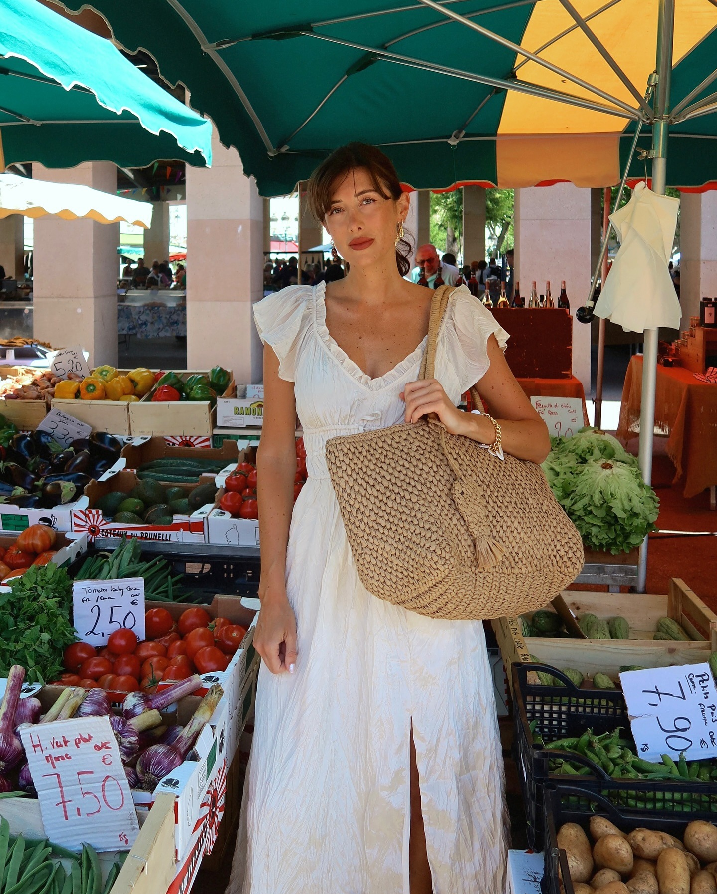 French influencer wearing a white dress and a raffia tote