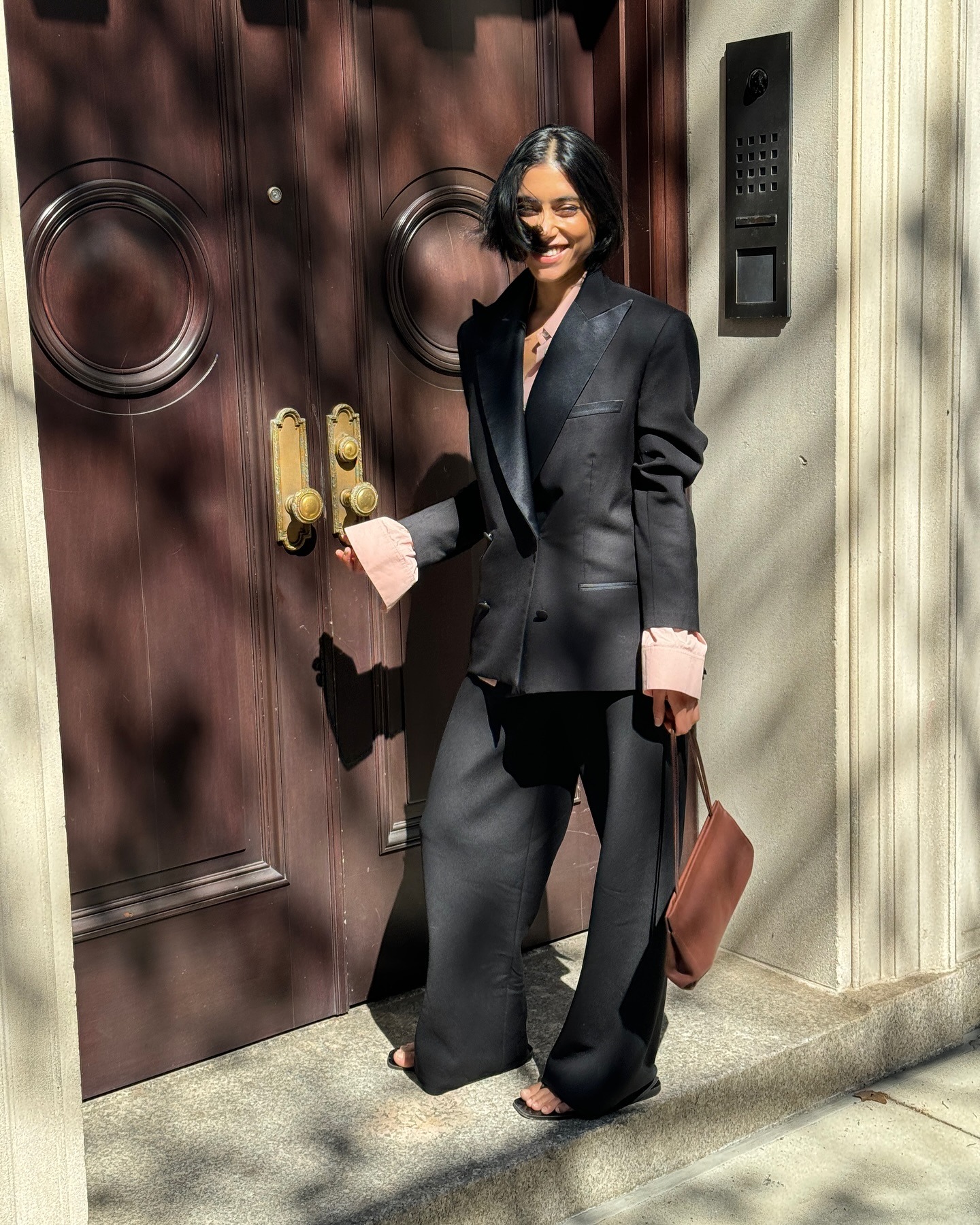 @shayinjune wearing a black suit with a pink shirt underneath.