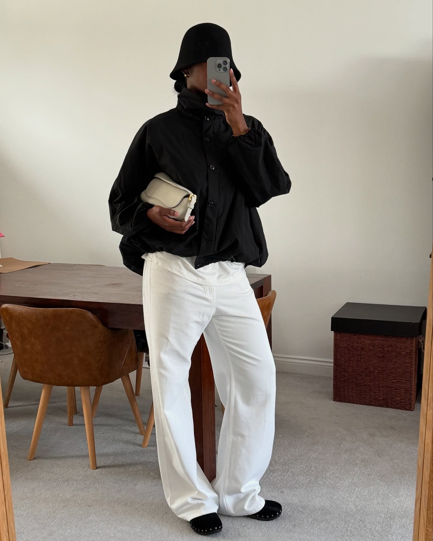 @nlmarilyn wearing a sporty jacket, cloche hat, and white jeans.