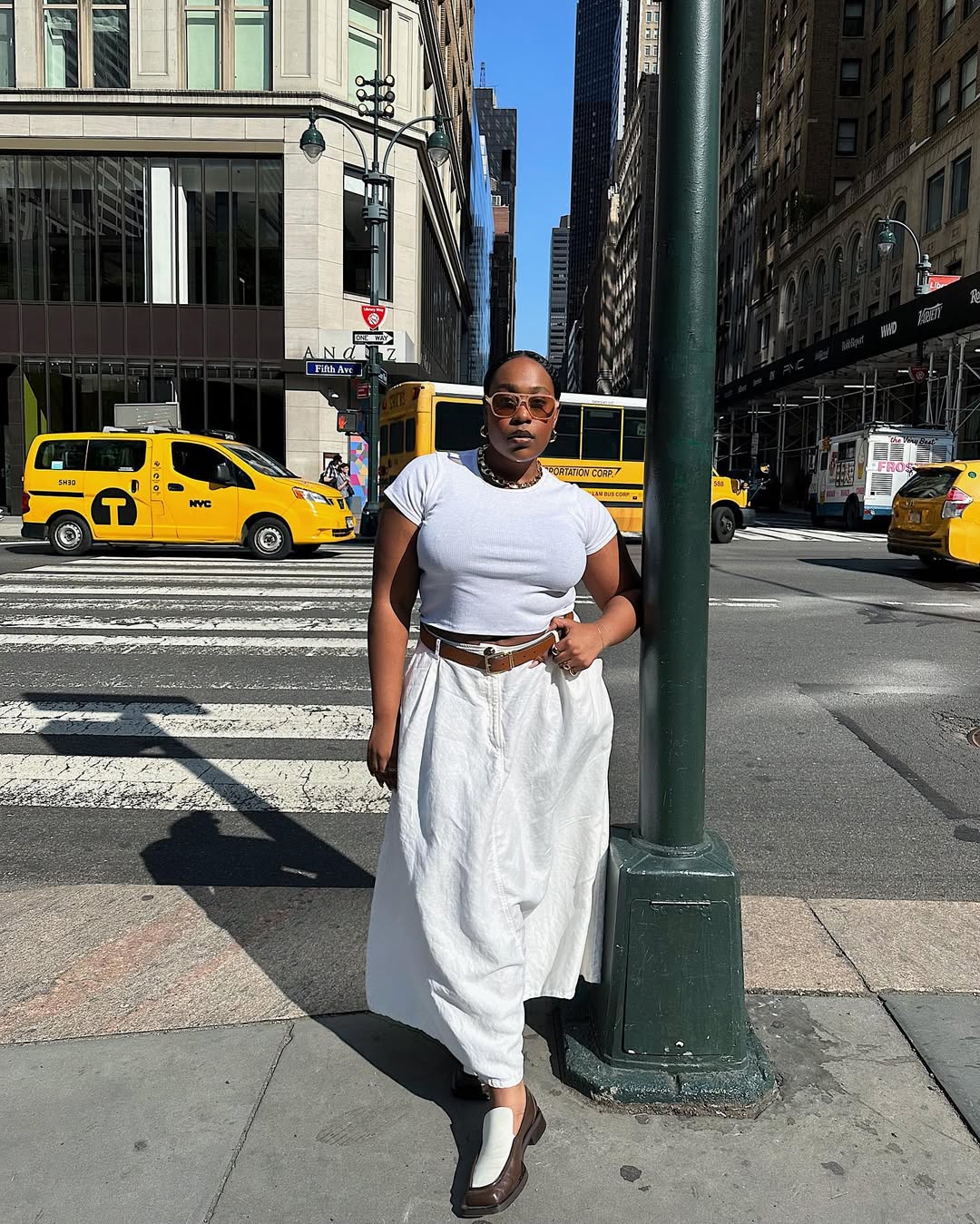 A woman wearing white t-shirt and long white skirt summer 2025.