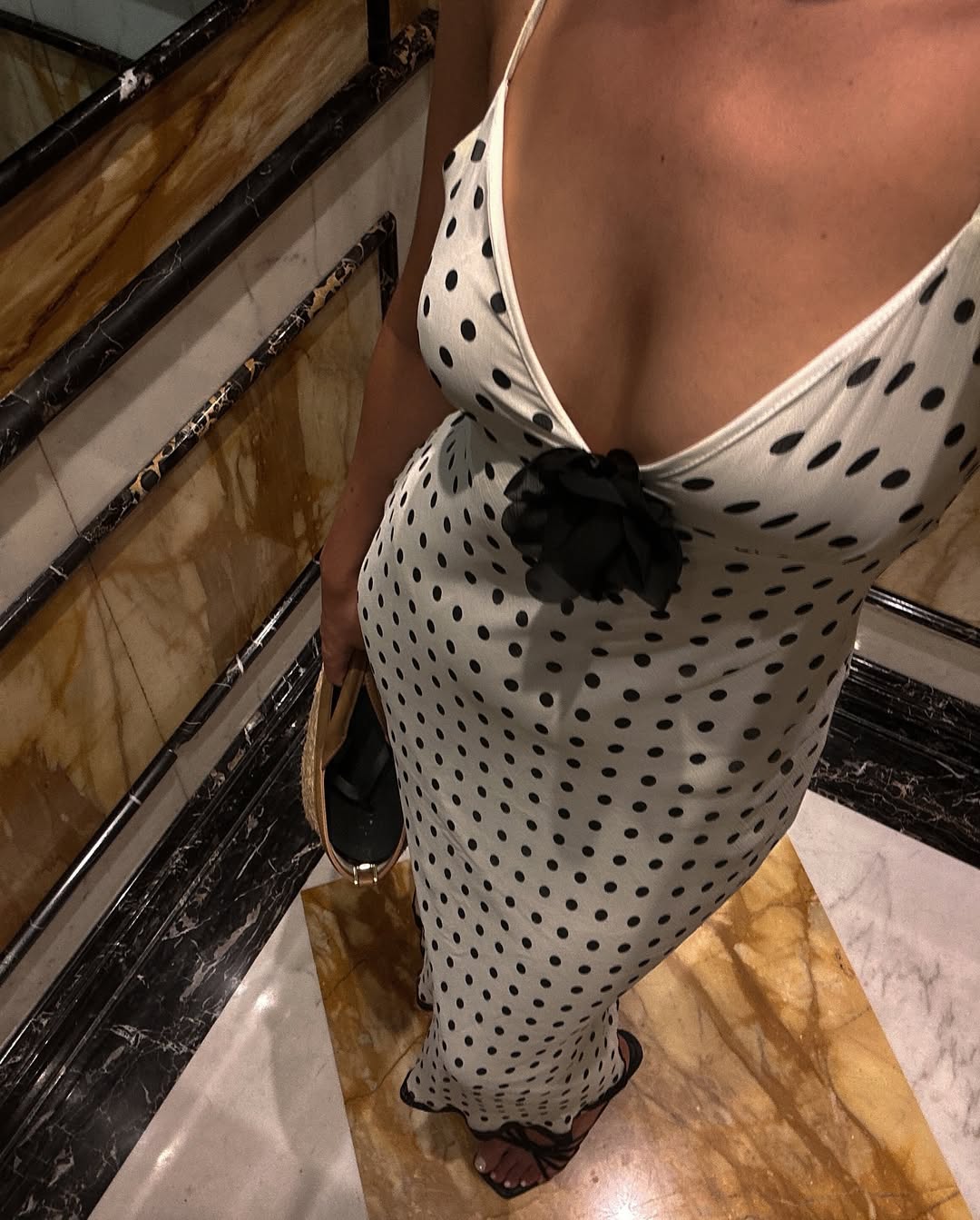 A woman wearing polka dot dress with rosette detail.