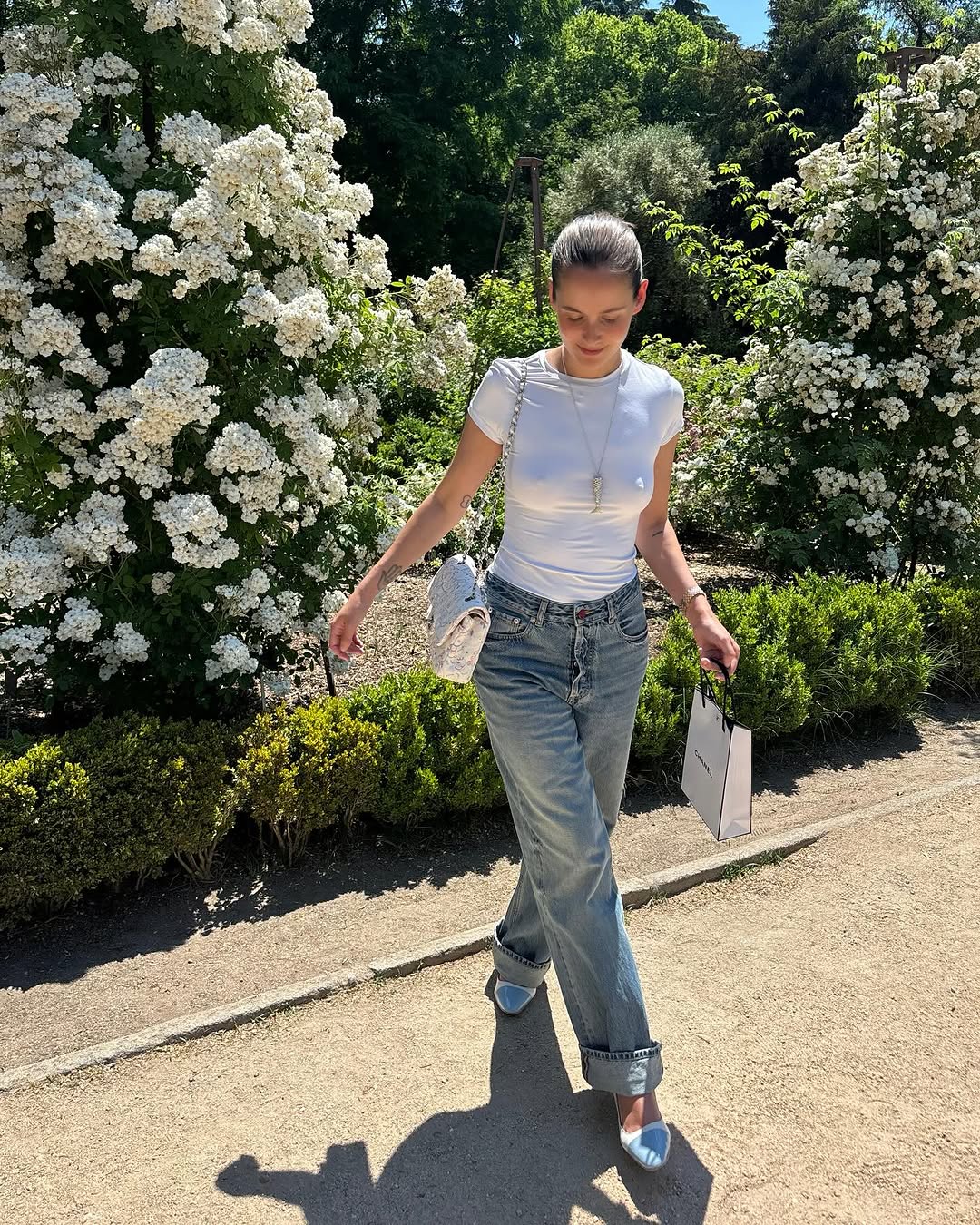 Woman wearing vintage jeans with white t shirt and cool bag.