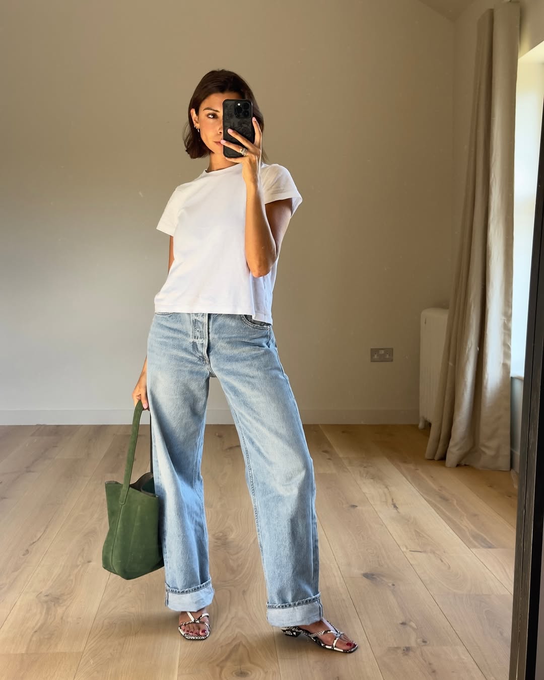 Woman wearing vintage jeans with white t shirt and cool bag.