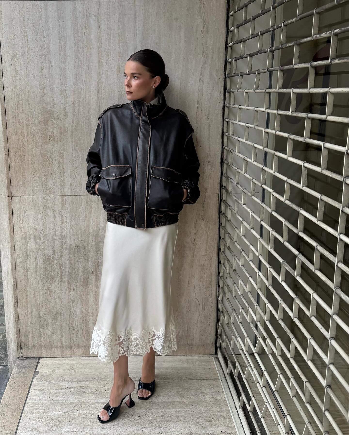 Rikke Krefting wearing a distressed leather bomber jacket with a cream lace-trim skirt.